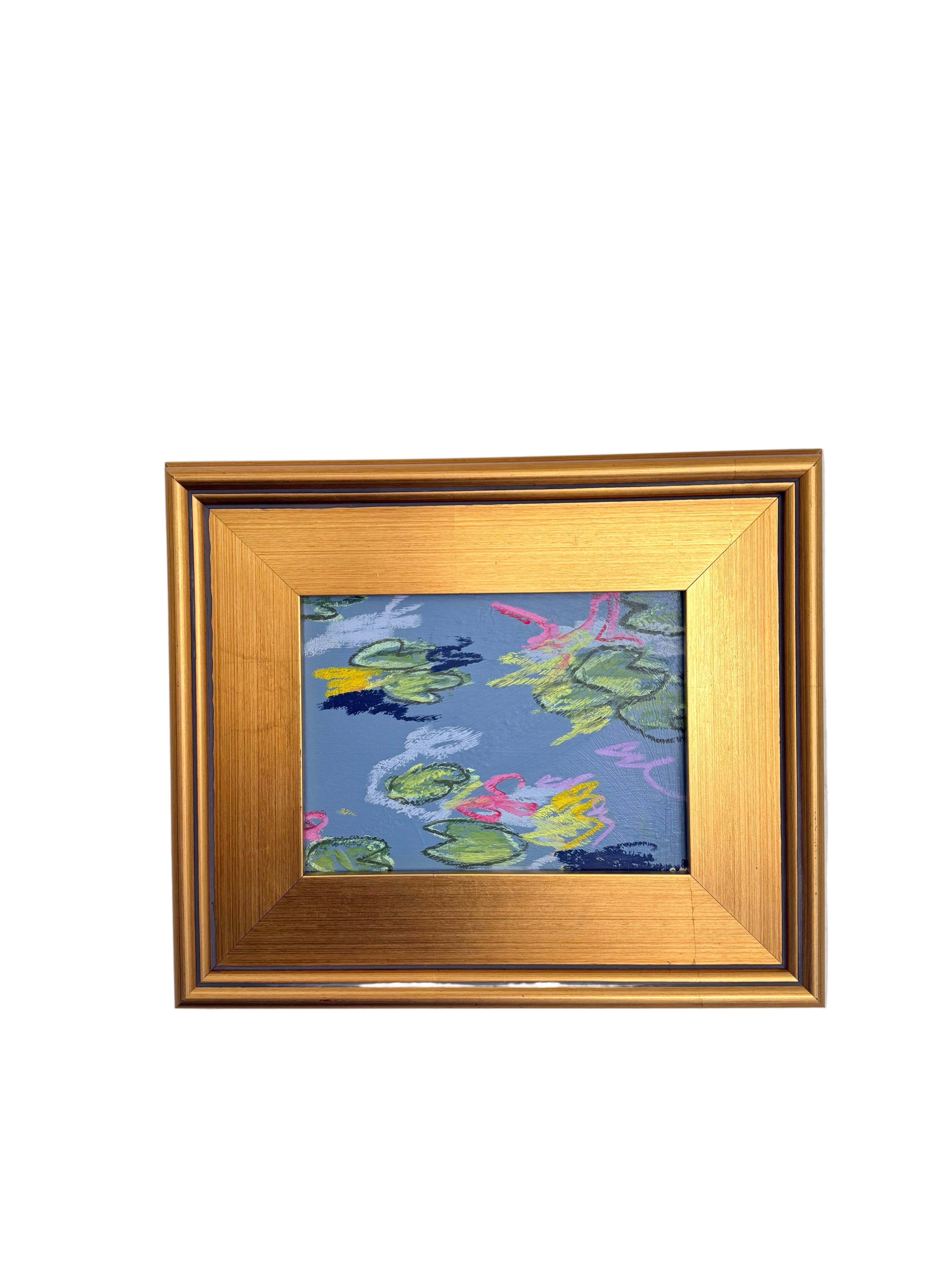 A small framed painting of a pond with lily pads, featuring a textured blue background with green, pink, and yellow painted pads, enclosed in a gold frame and mounted on a white textured wall.