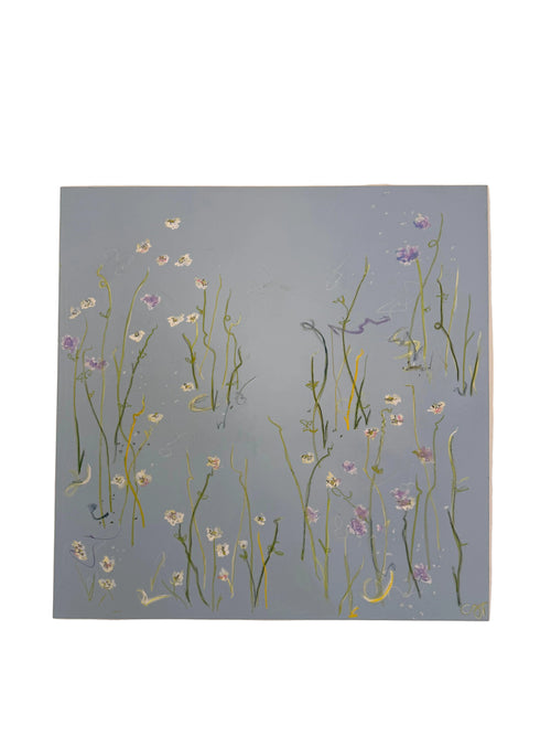 A square canvas painting of wildflowers on a muted blue-gray background, hung on a beige wall.